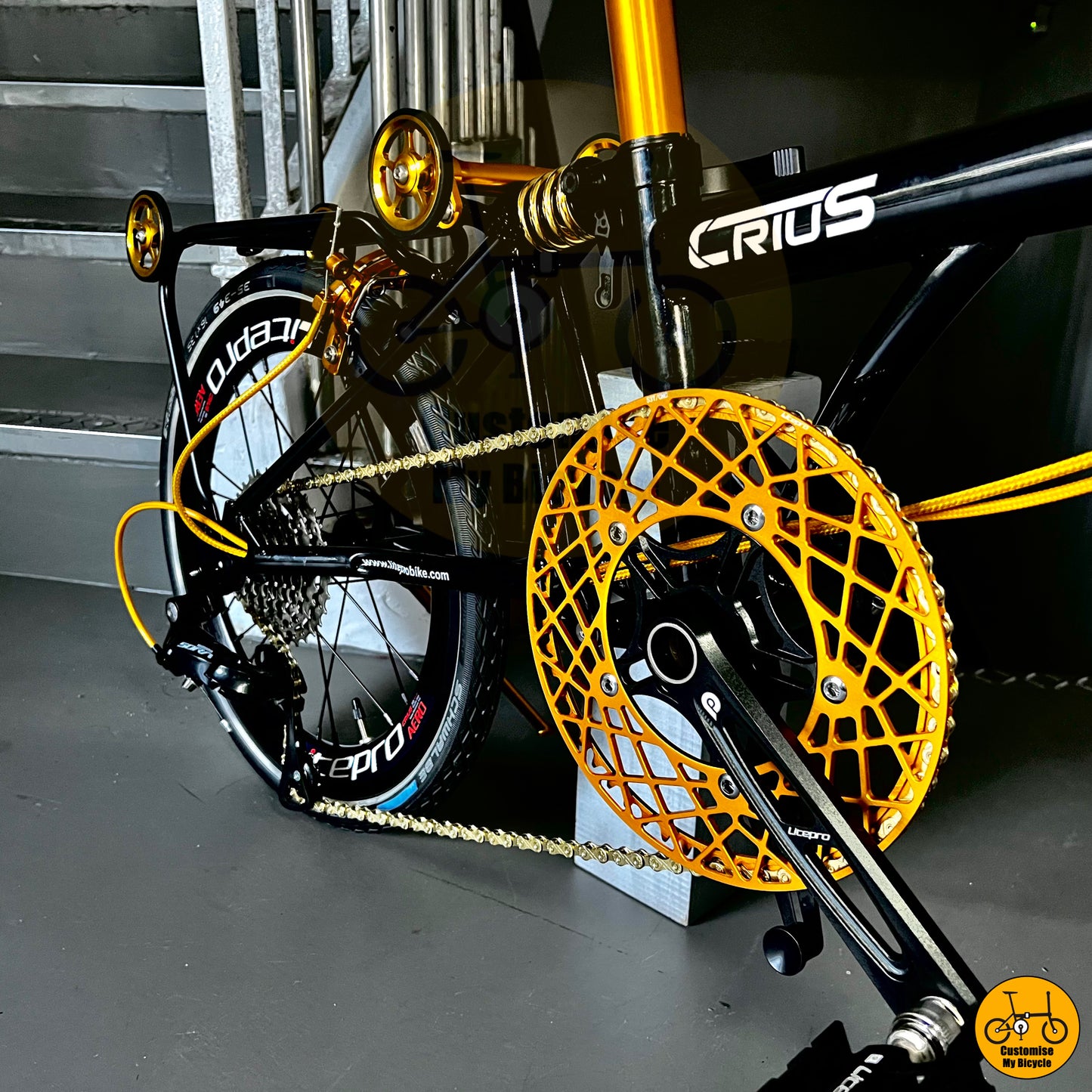 Foldable bike with gold-accented crankset and pedals
