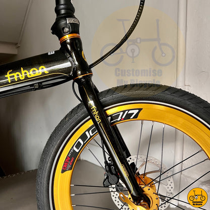 Close-up of a bicycle with yellow and black details, featuring the brand 'fnhan'.