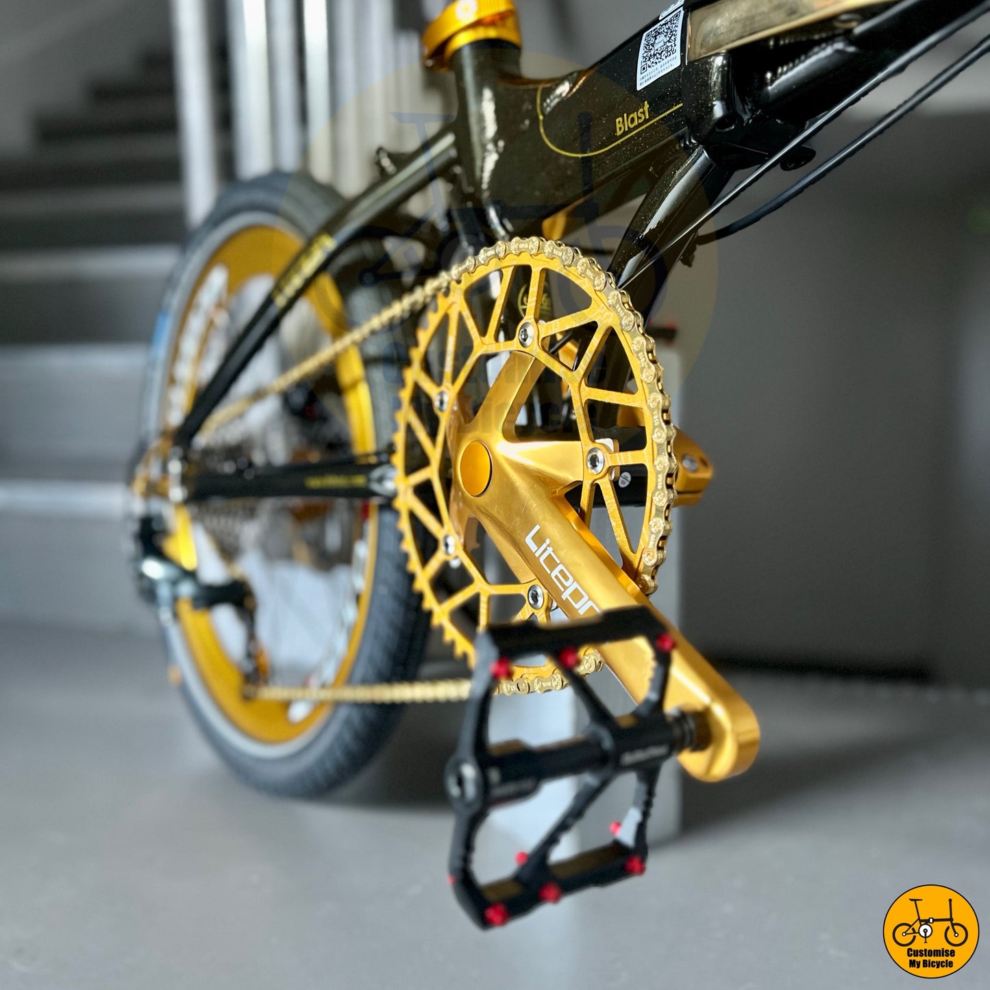 Close-up of a bicycle's gold chainring and gear with a blurred background