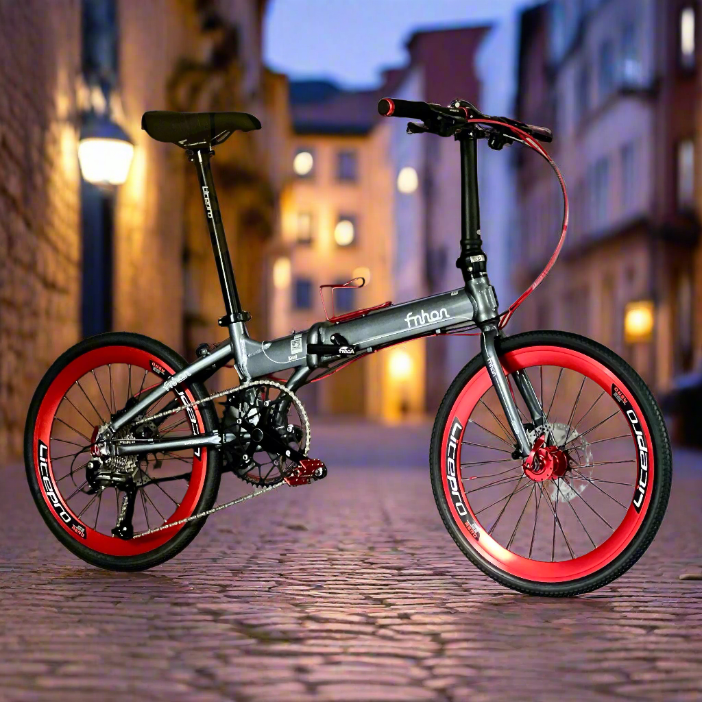 Foldable bicycle with red wheels on a cobblestone street at night.