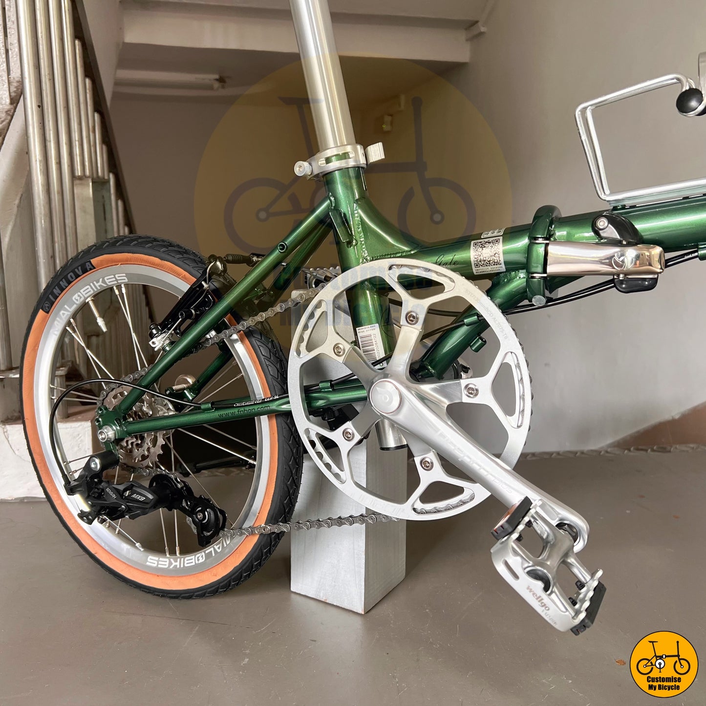 Emerald green foldable bicycle with brown saddle and grips
