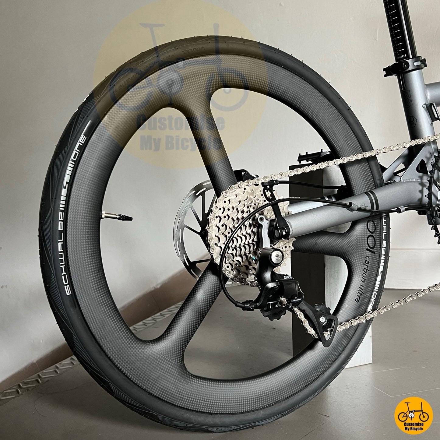 Folding bicycle with alloy frame, trispoke wheels and compact geometry
