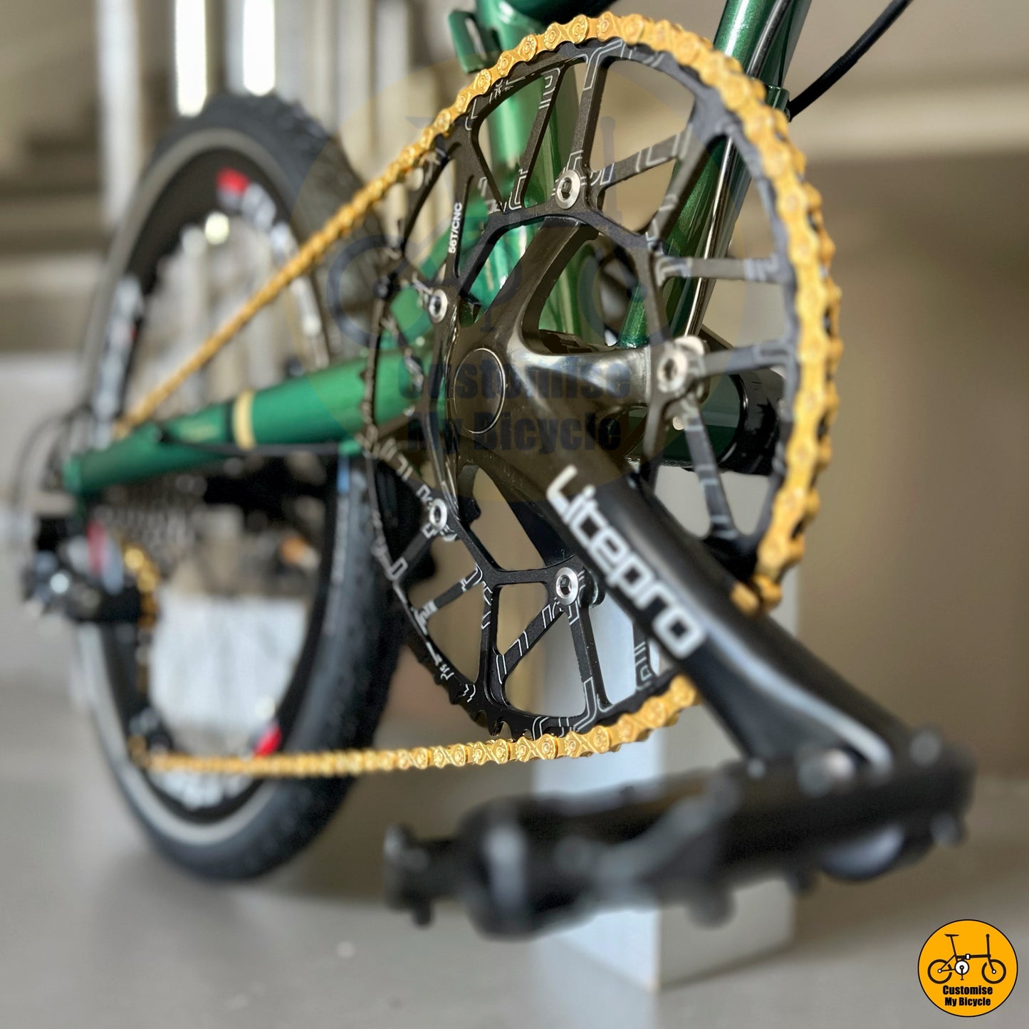 Emerald green foldable bicycle with PROMEND pedals and shinning gold chain