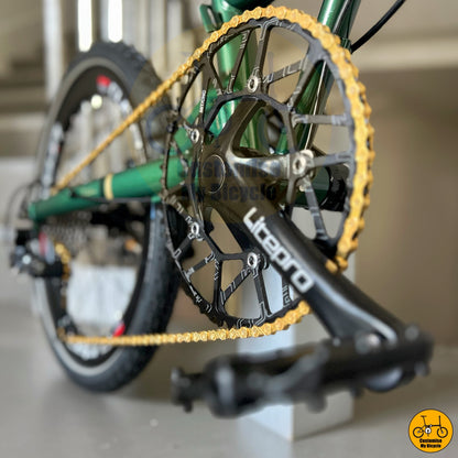 Emerald green foldable bicycle with PROMEND pedals and shinning gold chain