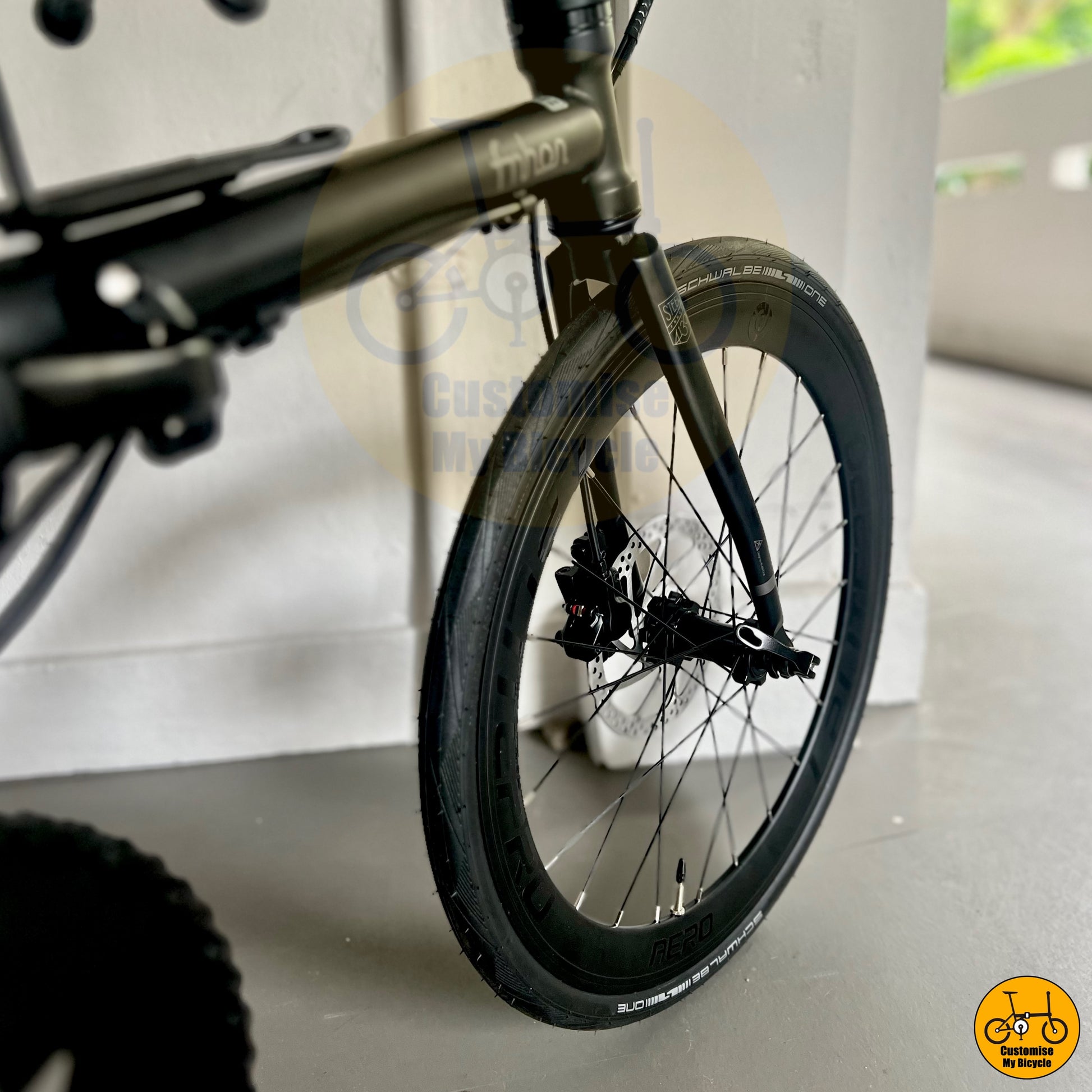 Schwalbe One 451 tyres on all-black lightweight folding bike for effortless city navigation
