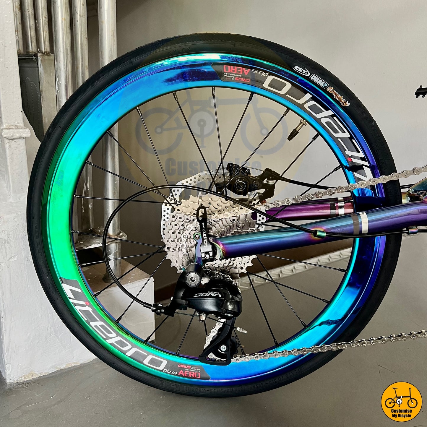 Folding bicycle with shimmering rainbow accents on the frame and wheels
