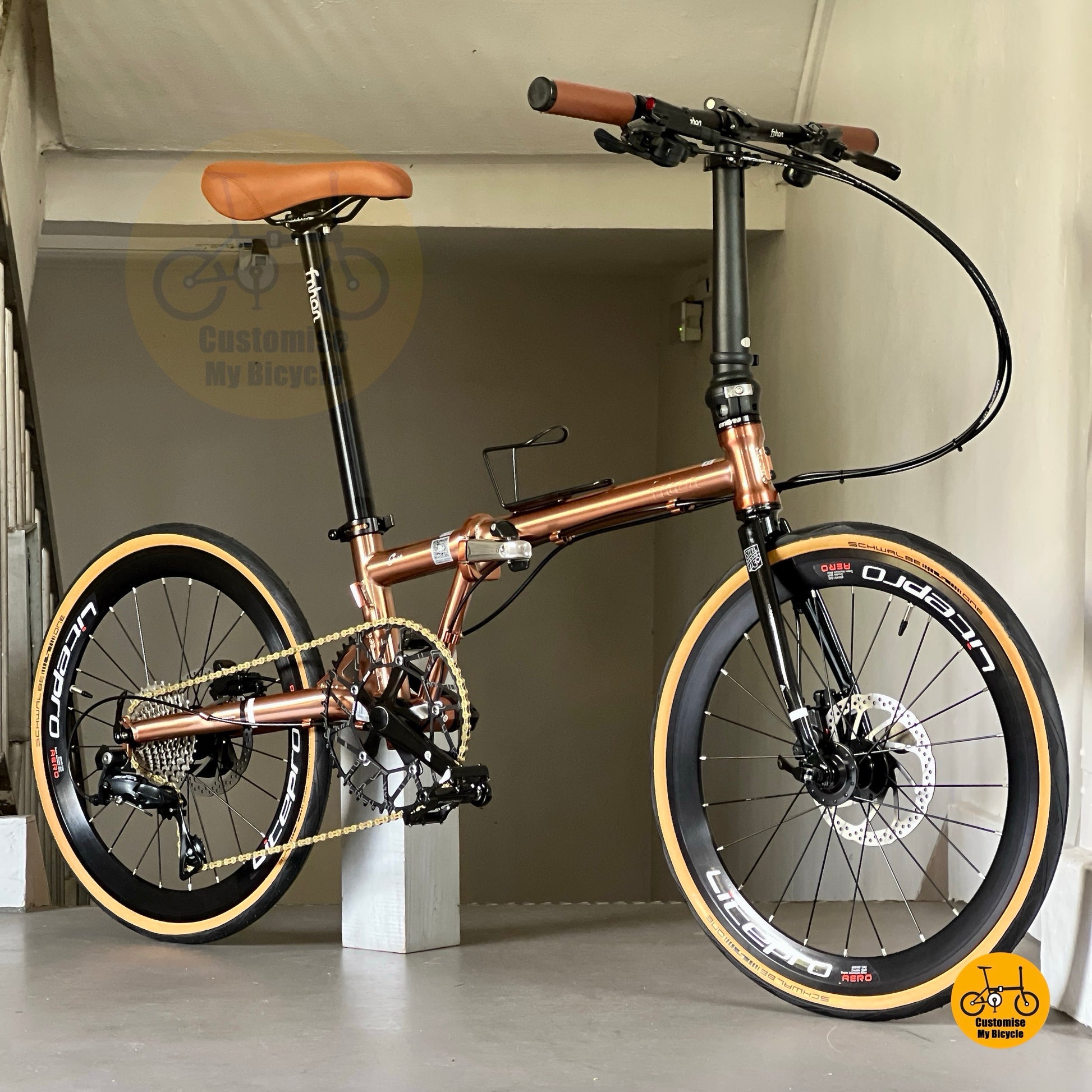 4. Stylish Fnhon Gust rose gold 22-inch foldie with brown saddle and grips, photographed outdoors on sunlit decking.
