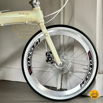 Foldable beige bicycle with white wall tyres  
