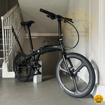 Matte black foldable bicycle with tri-spoke carbon wheels for smooth performance on road and PCN