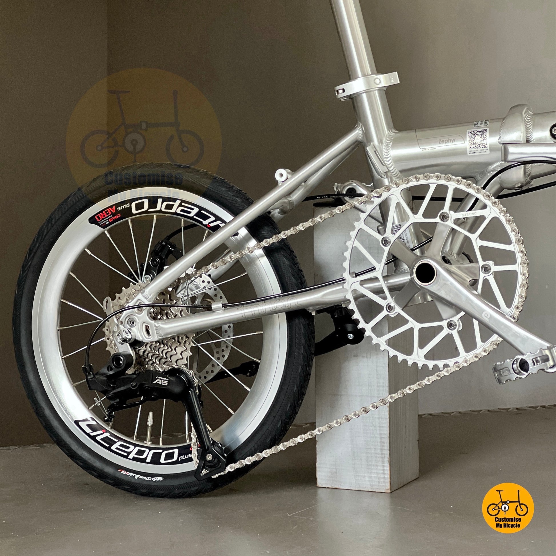 Close-up of Fnhon Zephyr polished silver crankset and chainring, showing CNC-machined details and reflective finish.
